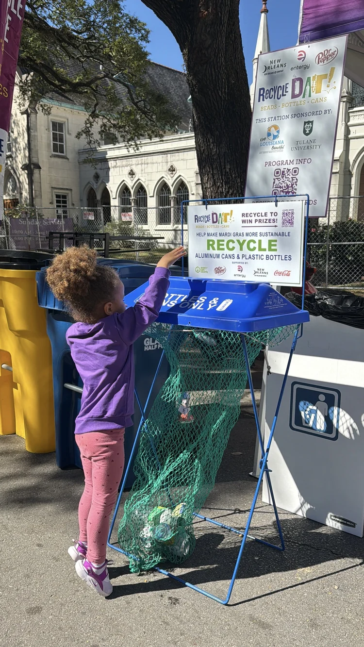 Kid dropping a bottle into a RecycleDAT bin