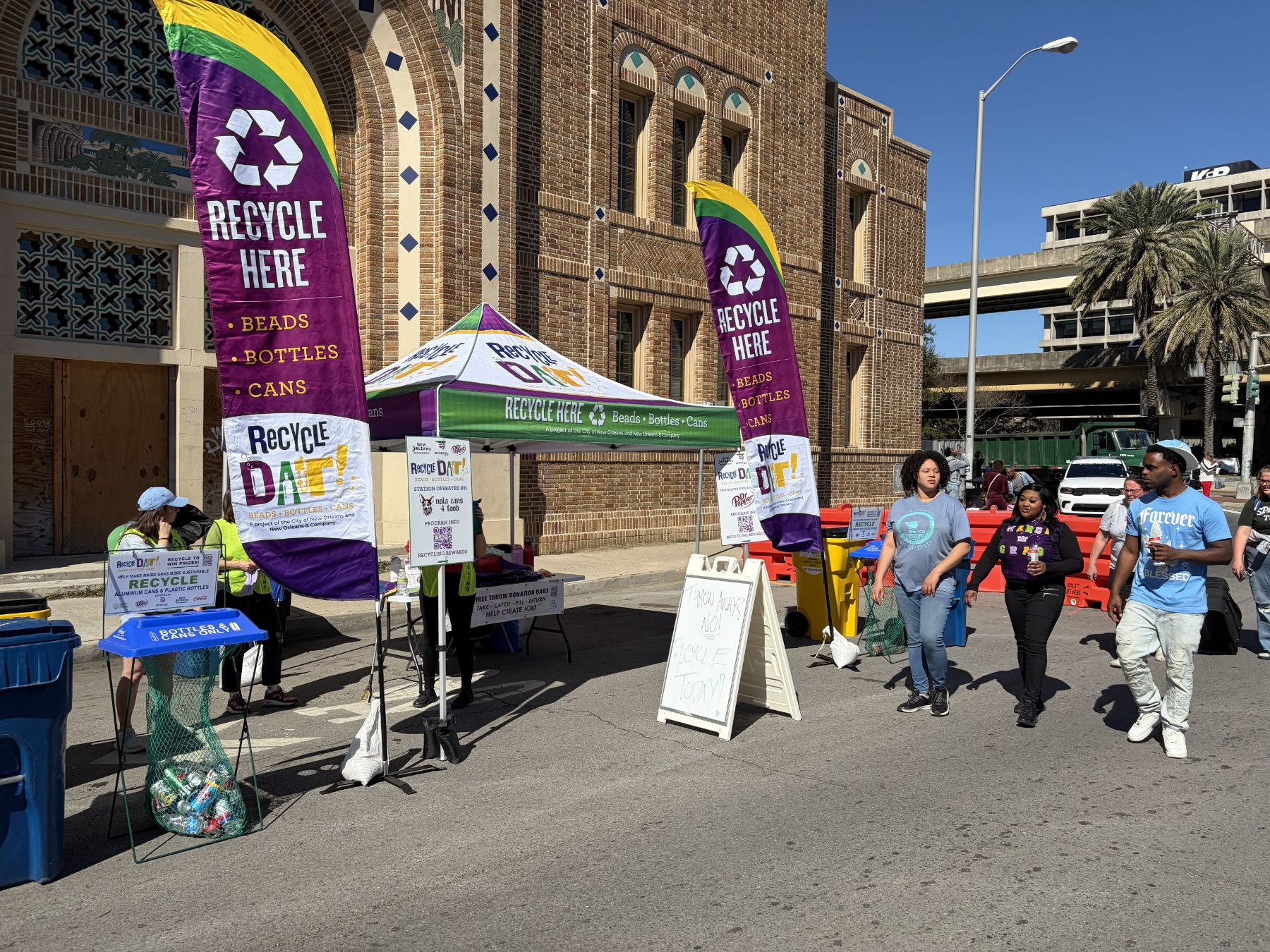 RecycleDAT station with Recycle Here banners and tent on the parade route