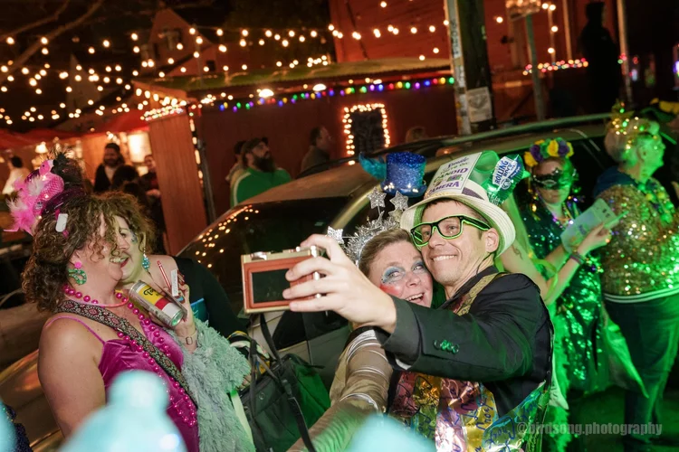 Krewe member dressed entirely in shredded plastic bags, glowing recycle symbol in the background